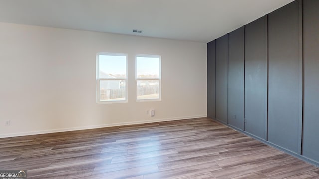 unfurnished bedroom with visible vents, light wood-style flooring, and baseboards