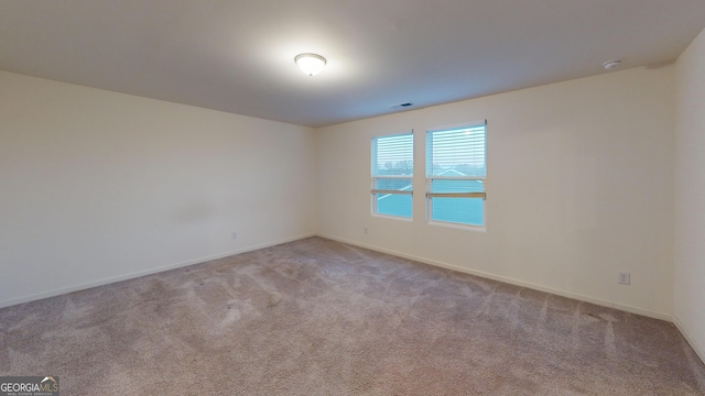 unfurnished room featuring light carpet, visible vents, and baseboards