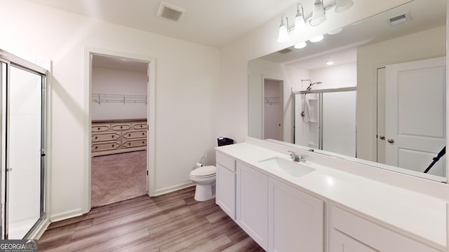 full bath with a shower stall, visible vents, and wood finished floors