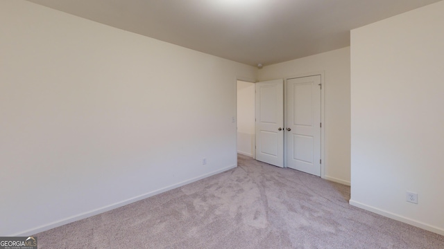 unfurnished bedroom featuring baseboards and light colored carpet