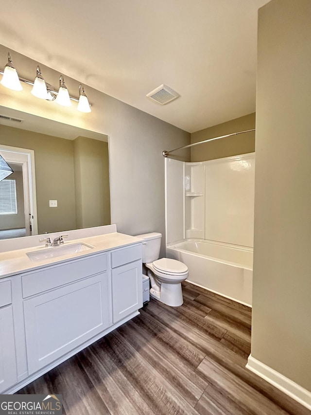 full bathroom with toilet, vanity, wood finished floors, and visible vents