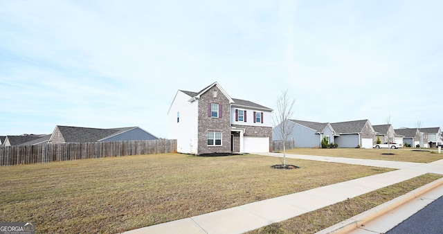 traditional-style house with concrete driveway, an attached garage, fence, a residential view, and a front lawn