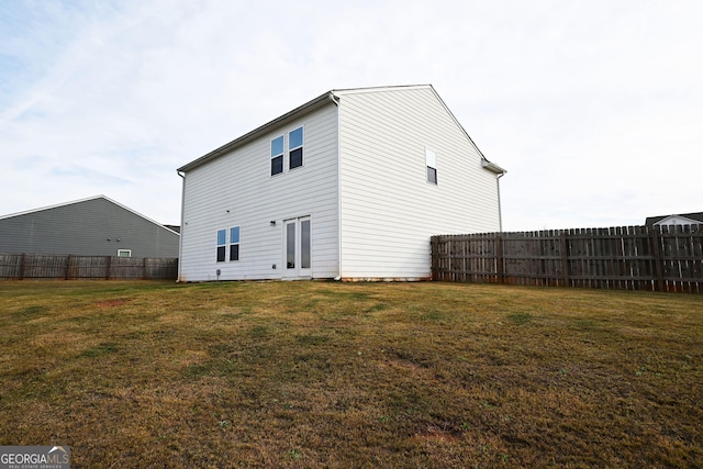 rear view of property with fence and a yard