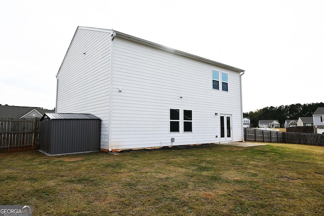 rear view of house featuring a fenced backyard, a shed, an outdoor structure, and a yard