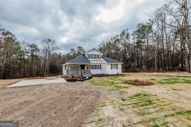 view of front of house with covered porch and a wooded view