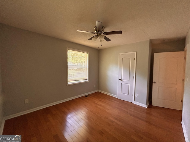 47 Elm St, Hampton, GA 30228 - unfurnished bedroom featuring wood finished floors, a textured ceiling, baseboards, and a ceiling fan