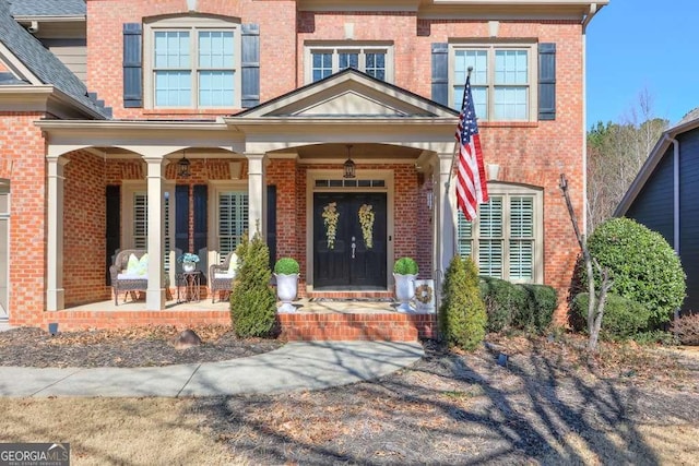 view of exterior entry featuring covered porch