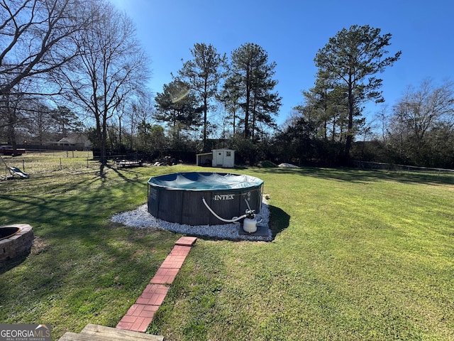 view of yard featuring a storage shed and a covered pool