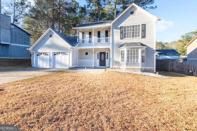 front facade featuring a garage, a balcony, a porch, and a front yard