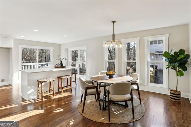 dining space featuring a healthy amount of sunlight, a chandelier, and dark wood-type flooring