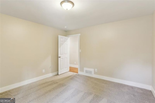 unfurnished room featuring light colored carpet