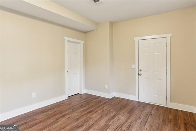 empty room with dark hardwood / wood-style flooring