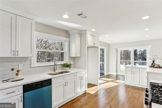 kitchen featuring hardwood / wood-style flooring, dishwasher, white cabinets, sink, and a healthy amount of sunlight