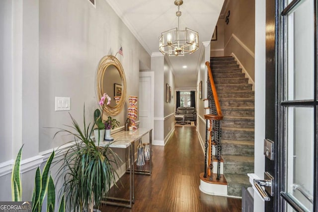 entrance foyer with an inviting chandelier, dark hardwood / wood-style floors, and ornamental molding