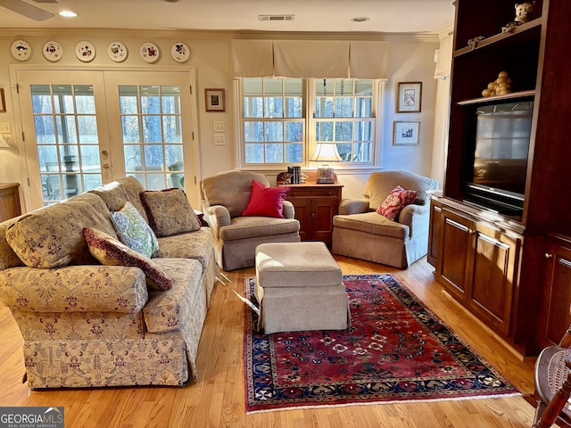 living area featuring visible vents, wood finished floors, crown molding, french doors, and recessed lighting