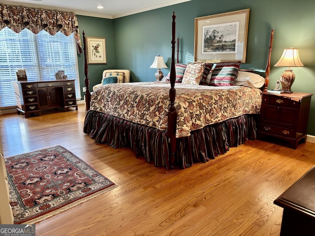 bedroom with ornamental molding and wood finished floors