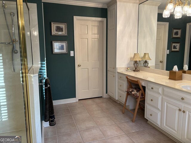 bathroom with tile patterned flooring, a shower with shower door, vanity, baseboards, and ornamental molding