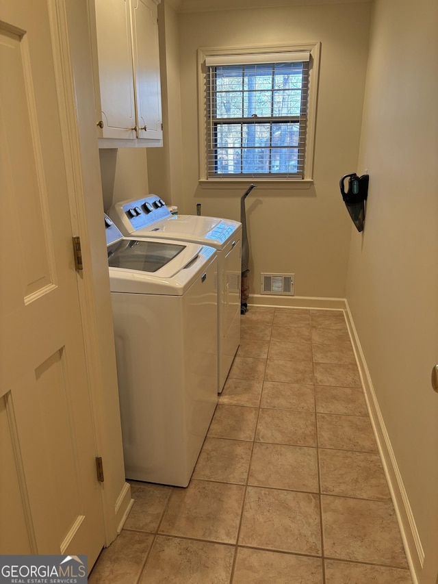 laundry area featuring cabinet space, visible vents, light tile patterned flooring, separate washer and dryer, and baseboards