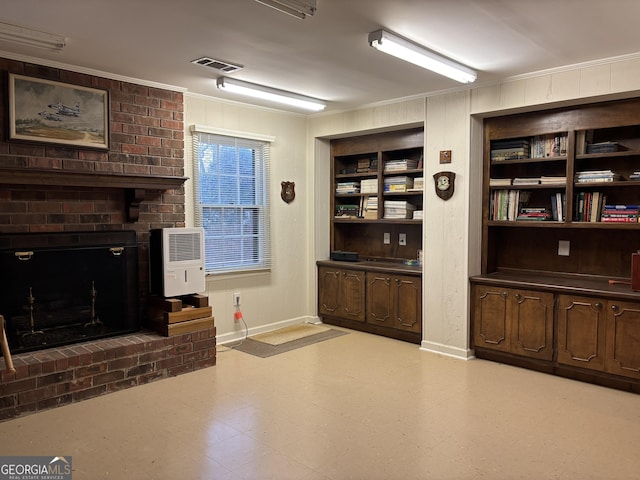 living room with heating unit, light floors, built in features, and crown molding