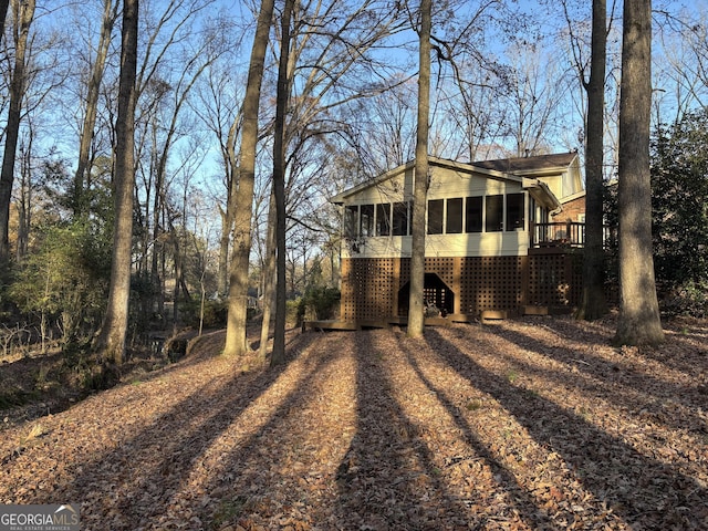 view of property exterior with driveway and a sunroom