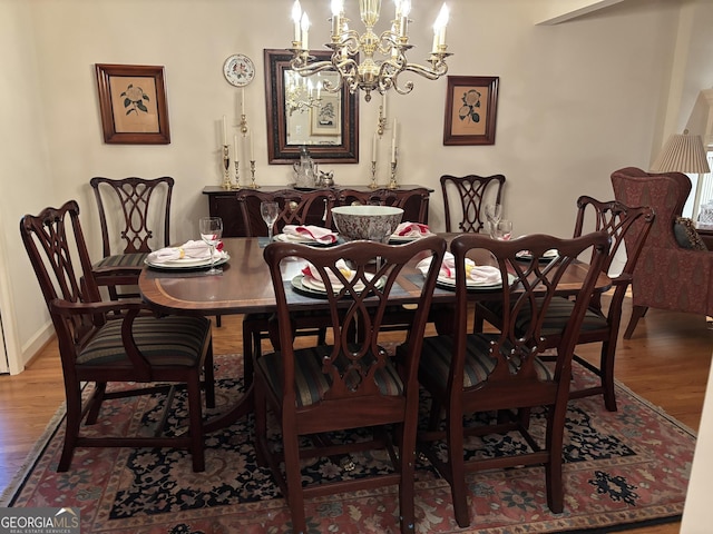 dining room with baseboards, wood finished floors, and an inviting chandelier