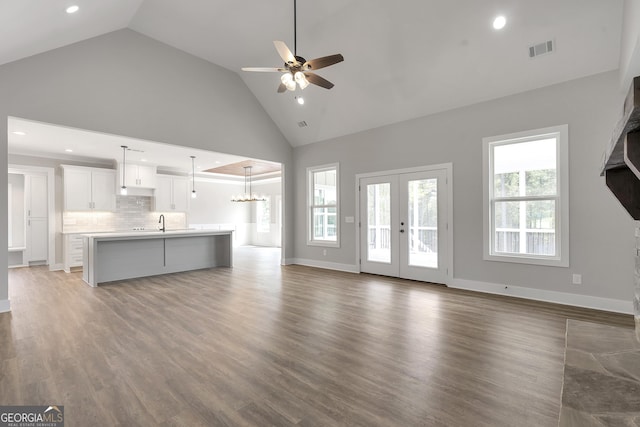 unfurnished living room featuring dark hardwood / wood-style flooring, high vaulted ceiling, and a healthy amount of sunlight