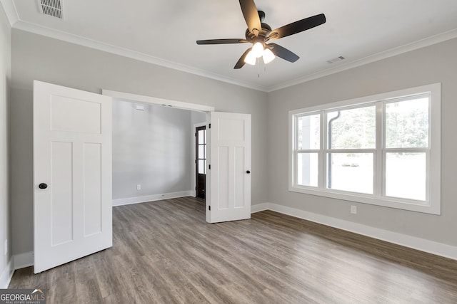 unfurnished bedroom with ceiling fan, wood-type flooring, and ornamental molding