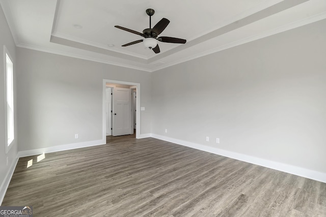 spare room with ceiling fan, crown molding, a raised ceiling, and hardwood / wood-style floors