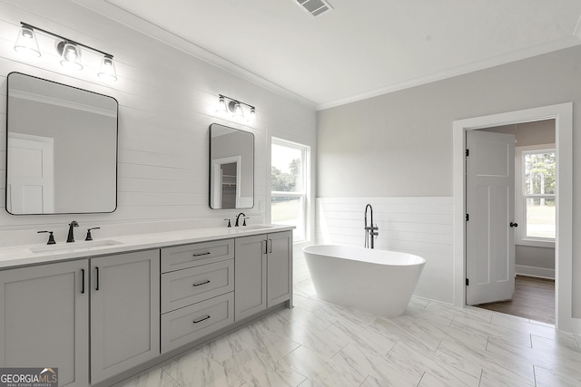 bathroom with a tub, vanity, and ornamental molding