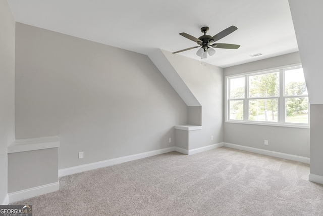 bonus room with ceiling fan and light carpet