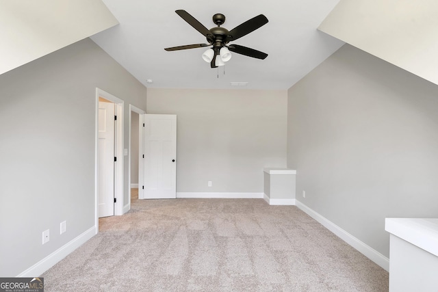 additional living space featuring ceiling fan and light colored carpet