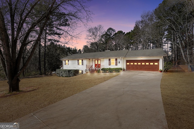 ranch-style home with a garage and a yard