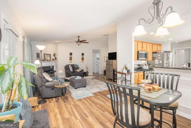 dining area with light hardwood / wood-style flooring and ceiling fan