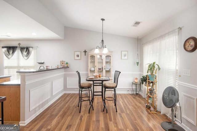 dining space featuring wood-type flooring and a healthy amount of sunlight