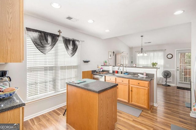 kitchen featuring decorative light fixtures, a kitchen island, sink, dishwasher, and a chandelier