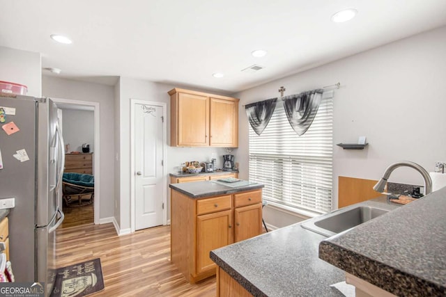 kitchen with a center island, sink, stainless steel refrigerator with ice dispenser, and light wood-type flooring