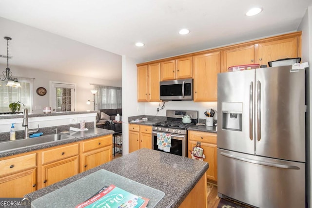 kitchen featuring appliances with stainless steel finishes, sink, and hanging light fixtures