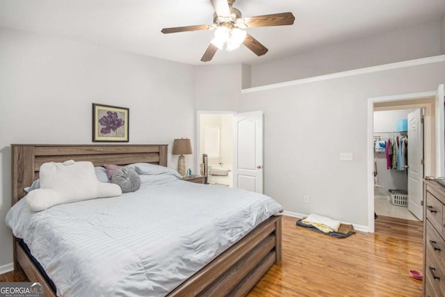 bedroom featuring ceiling fan, light wood-type flooring, a closet, and a spacious closet