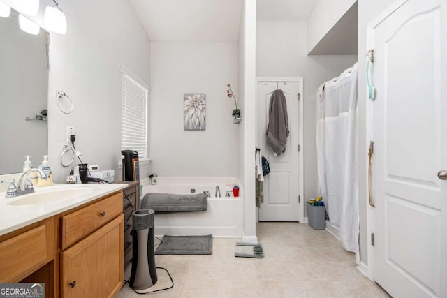 bathroom with tile patterned floors, a tub to relax in, and vanity