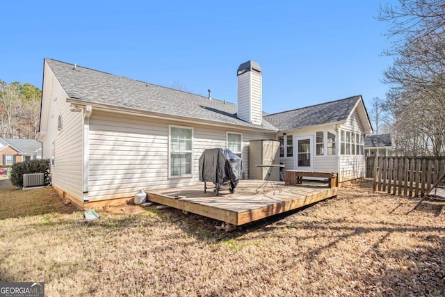 back of property with a deck, central AC unit, and a yard