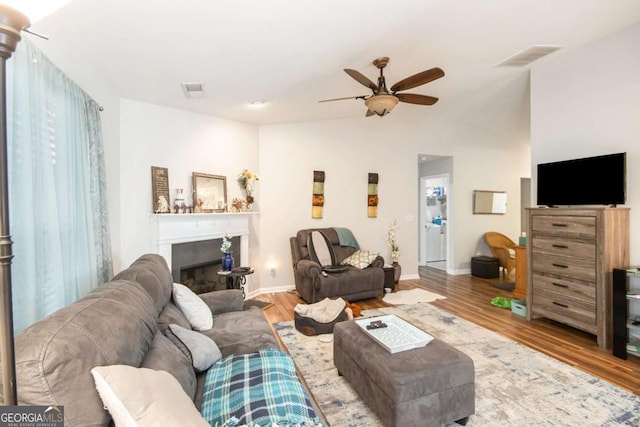 living room featuring light hardwood / wood-style flooring and ceiling fan