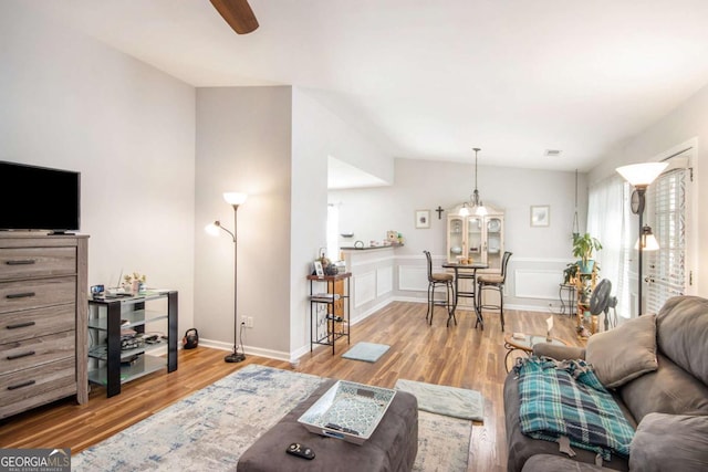 living room featuring vaulted ceiling and wood-type flooring