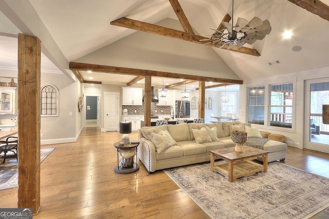 living room with beamed ceiling, ceiling fan, and light hardwood / wood-style flooring