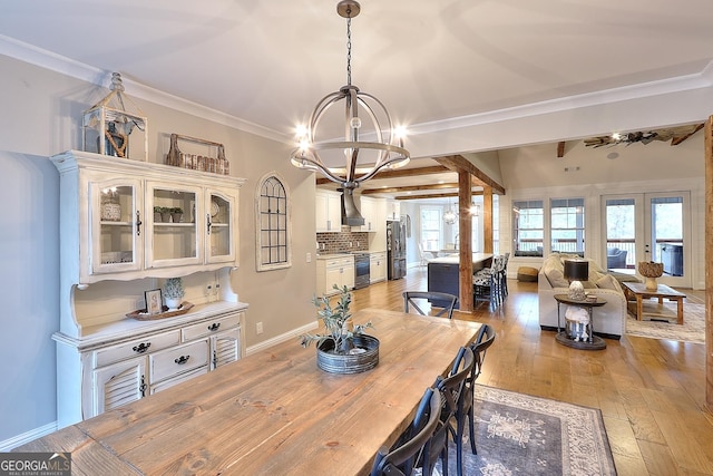 dining space featuring light hardwood / wood-style flooring, crown molding, and a notable chandelier