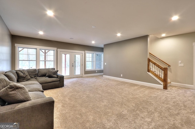 living room featuring french doors, light colored carpet, and a wealth of natural light