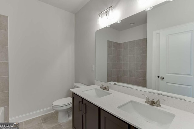 bathroom with toilet, vanity, and tile patterned flooring