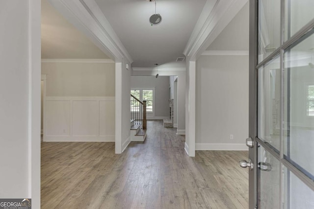 entryway featuring ornamental molding and light hardwood / wood-style flooring