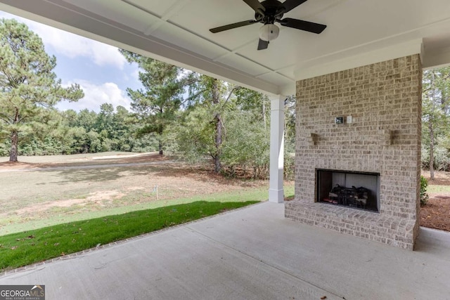 view of patio featuring ceiling fan and an outdoor brick fireplace