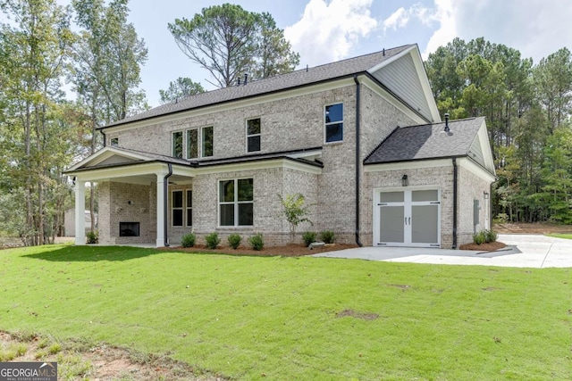 view of front of home featuring french doors, a front lawn, and an outdoor fireplace