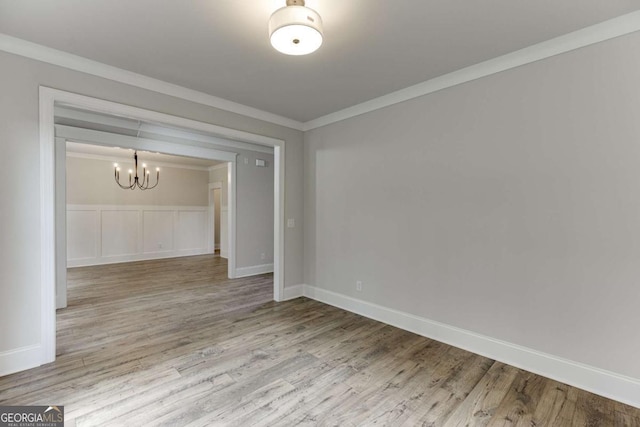 interior space with an inviting chandelier, crown molding, and hardwood / wood-style floors